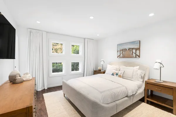 a bedroom with a large bed and a flat tv screen