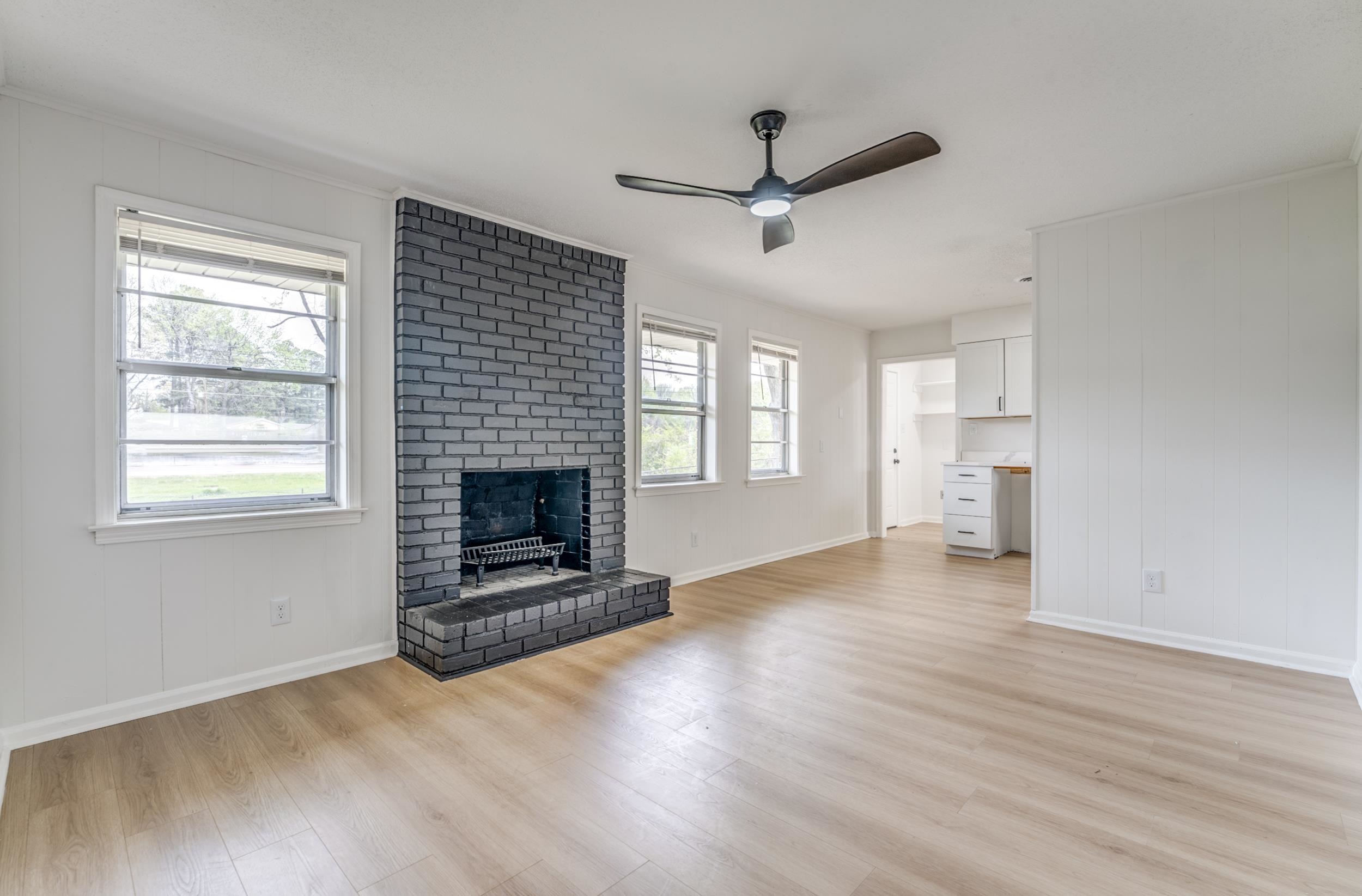 5156 Windcrest Road Memphis, TN 38116 - Photo 3 of 24 Unfurnished living room with a ceiling fan, a fireplace, and light wood-style flooring