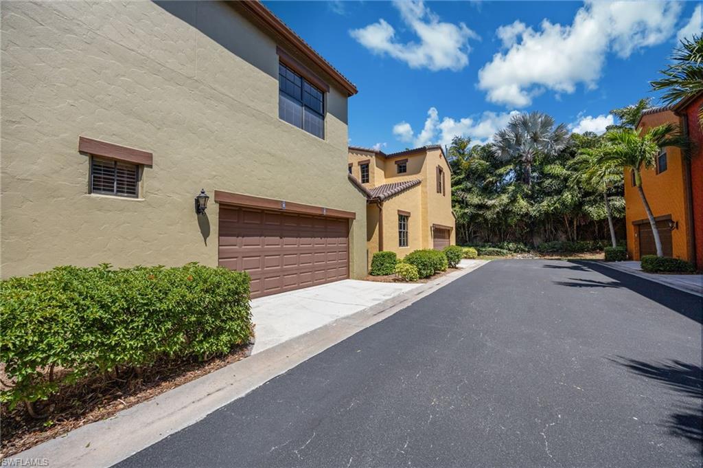 9128 Delano Street, Unit 892 Naples, FL 34113 - Photo 26 of 49 a front view of a house with a yard and garage
