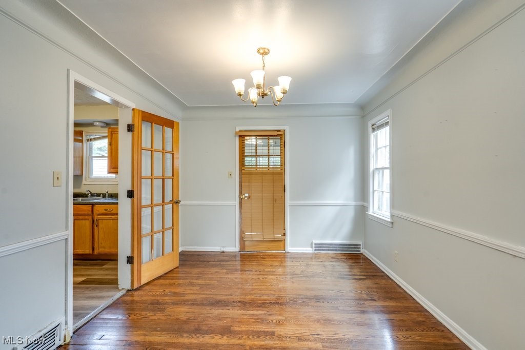 13677 Cedar Road Cleveland, OH 44118 - Photo 14 of 50 Unfurnished dining area featuring dark wood-style floors, plenty of natural light, a chandelier, and french doors