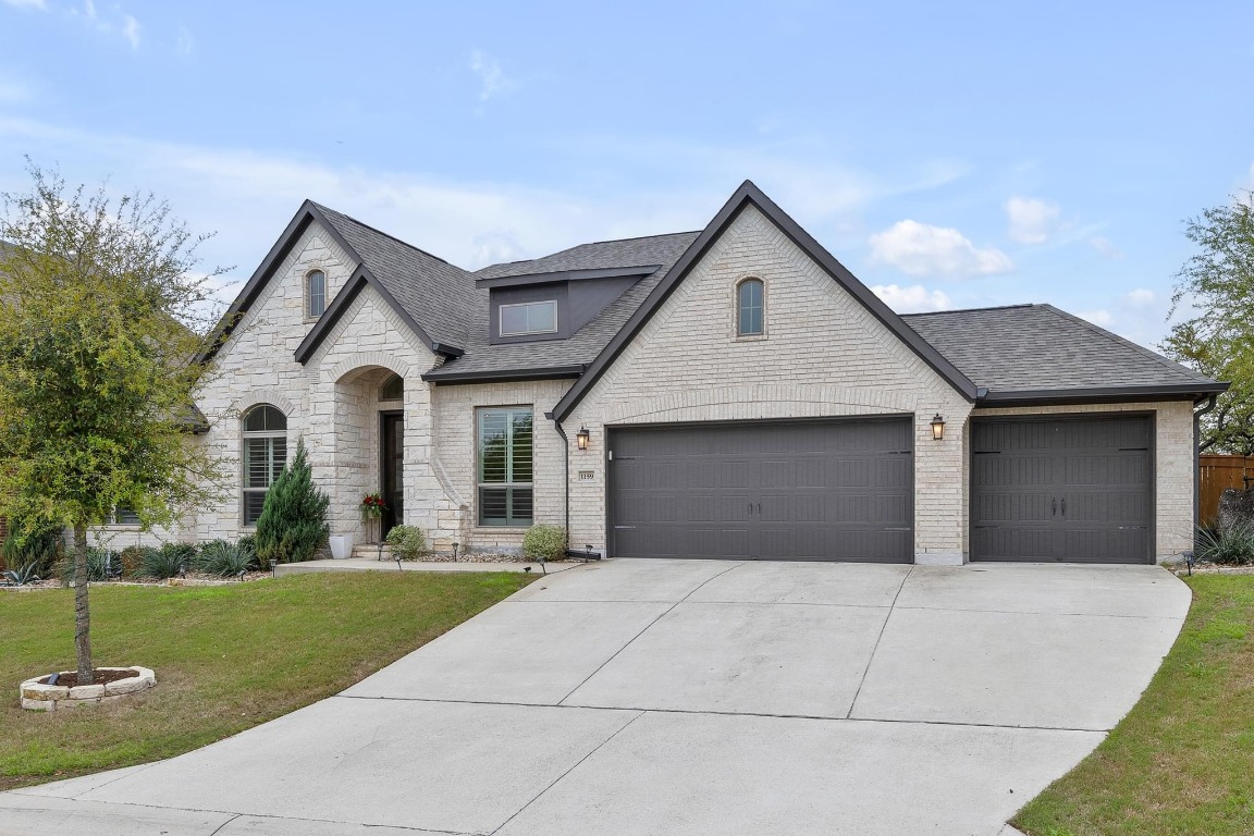 a front view of a house with a yard and trees
