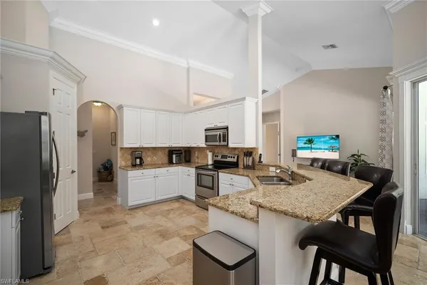 a kitchen with stainless steel appliances granite countertop a stove refrigerator and cabinets