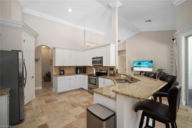 a kitchen with stainless steel appliances granite countertop a stove refrigerator and cabinets