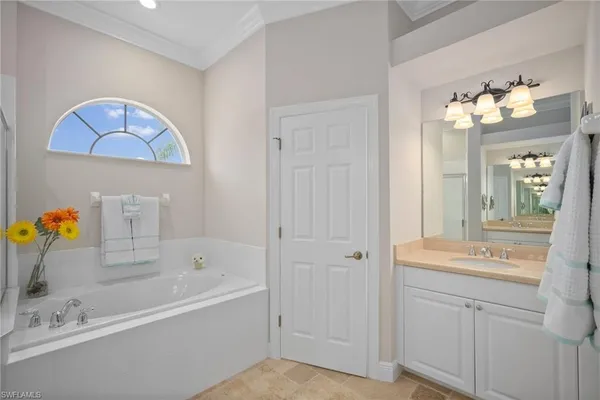 a bathroom with a tub a sink and a mirror