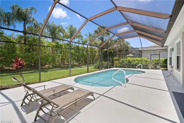 a view of a backyard with couches plants and palm trees