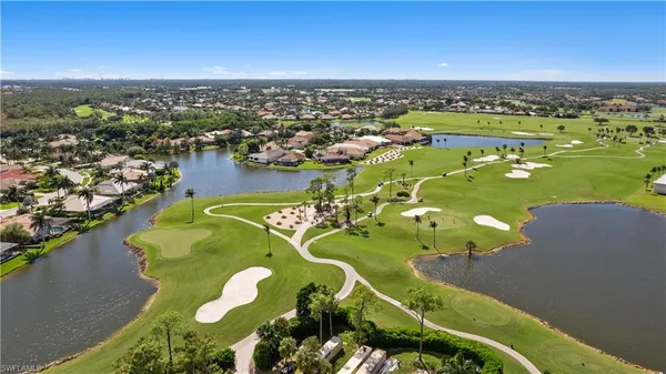 an aerial view of a city with lots of residential buildings ocean and mountain view in back
