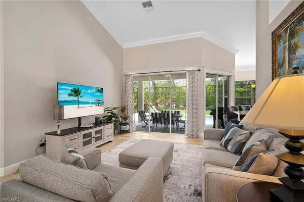 a living room with furniture a flat screen tv and a large window