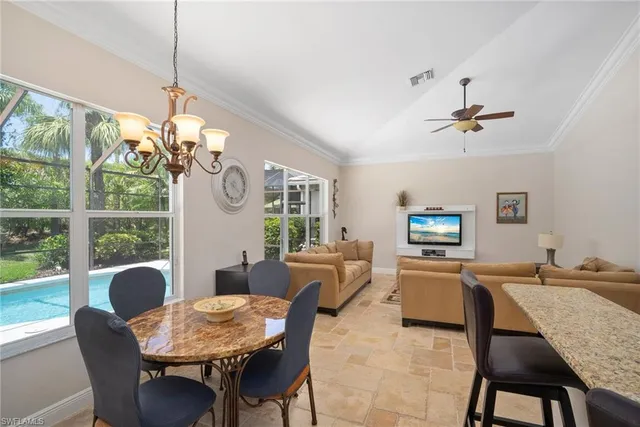 a view of a dining room with furniture a chandelier and a large window