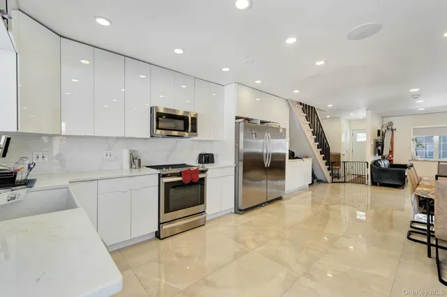 a kitchen with white cabinets and refrigerator