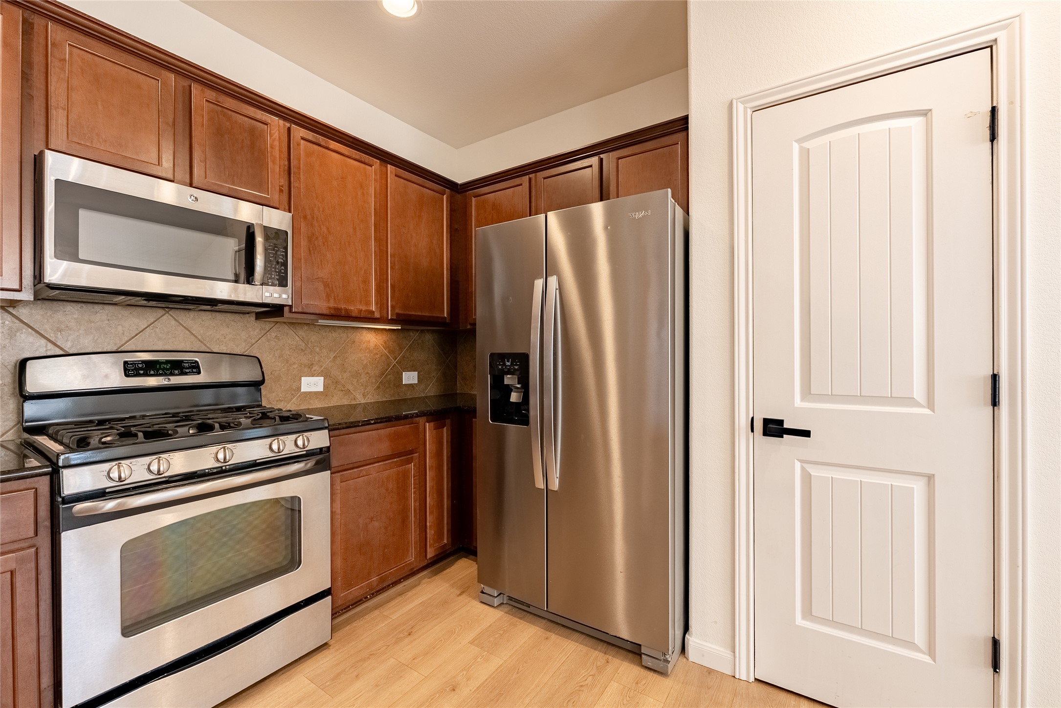1437 April Meadows Loop Georgetown, TX 78626 - Photo 11 of 31 a kitchen with stainless steel appliances granite countertop a refrigerator stove and microwave