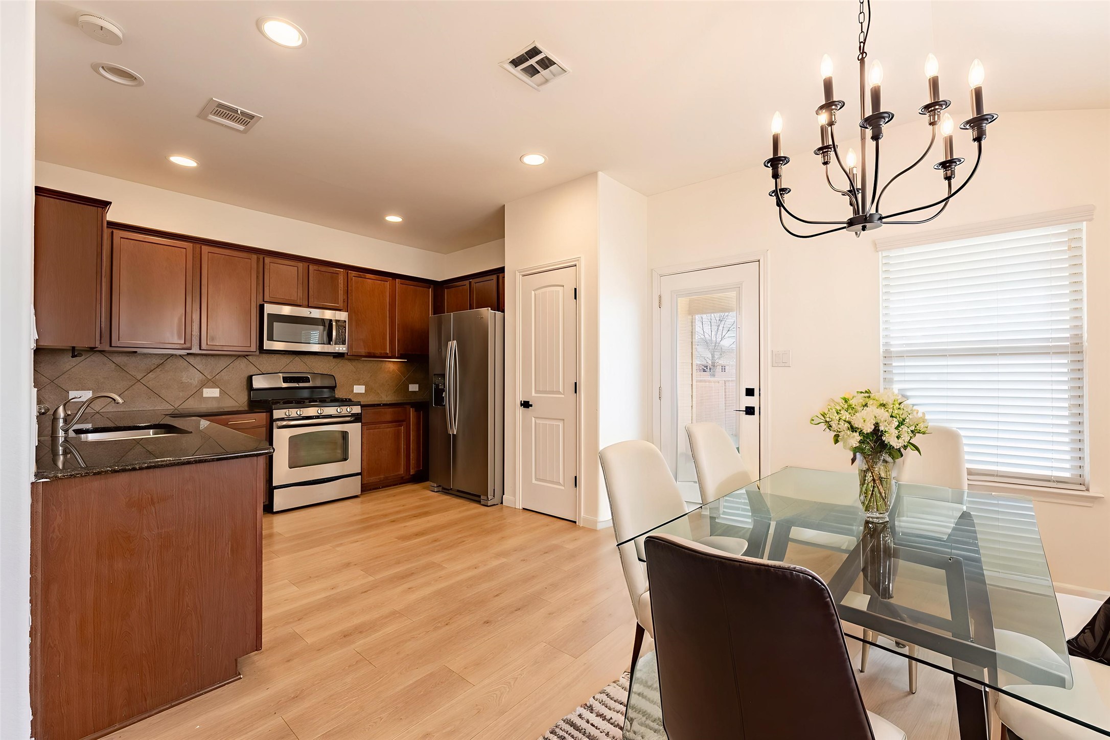 1437 April Meadows Loop Georgetown, TX 78626 - Photo 4 of 31 a kitchen with stainless steel appliances granite countertop a refrigerator a sink a stove and chairs