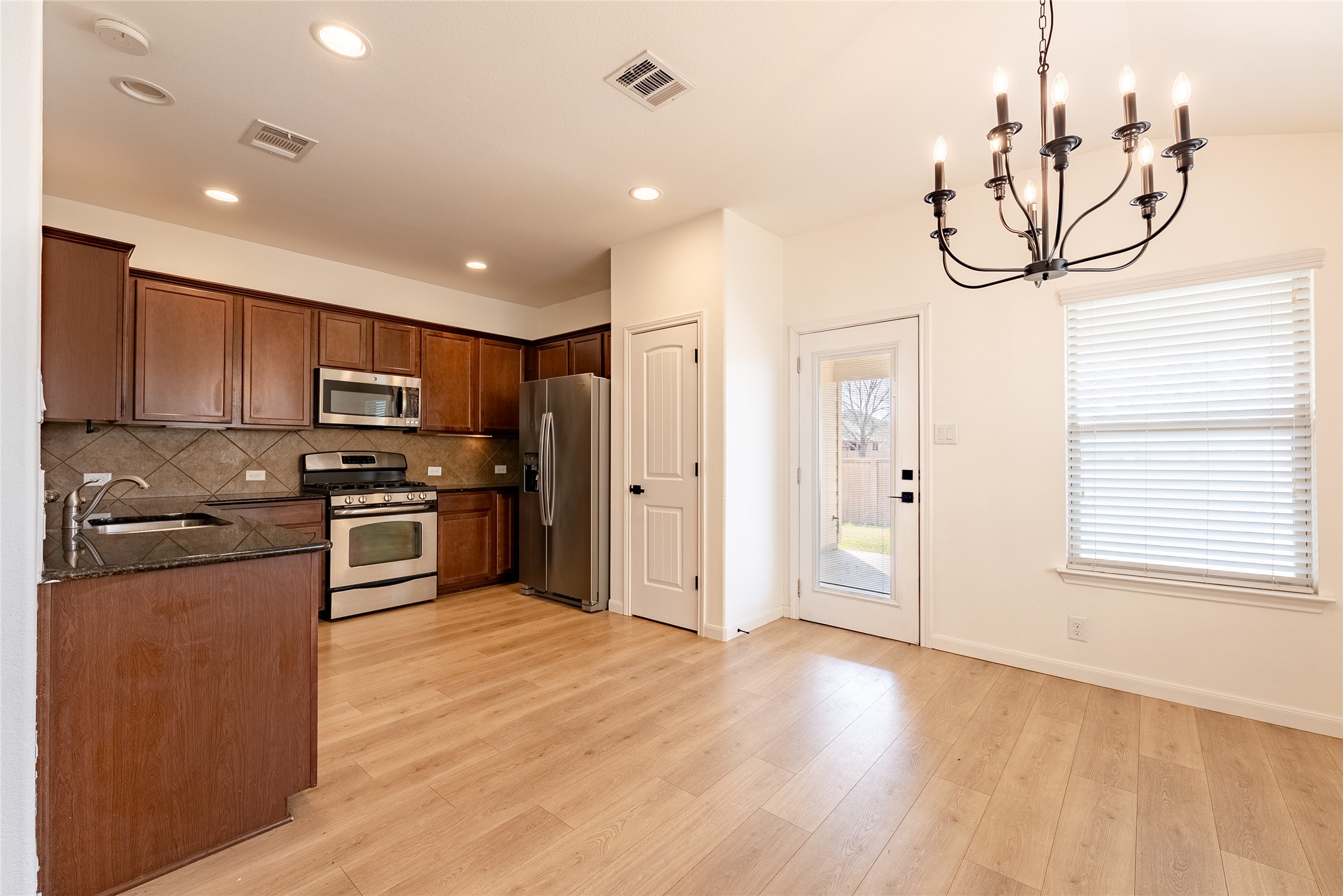 1437 April Meadows Loop Georgetown, TX 78626 - Photo 9 of 31 a kitchen with stainless steel appliances granite countertop a refrigerator and microwave