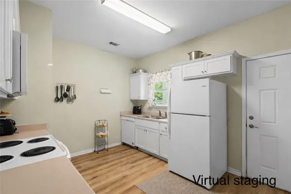 a kitchen with a refrigerator a stove top oven a sink and cabinets