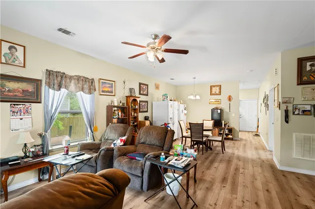 a living room with furniture a flat screen tv and a large window