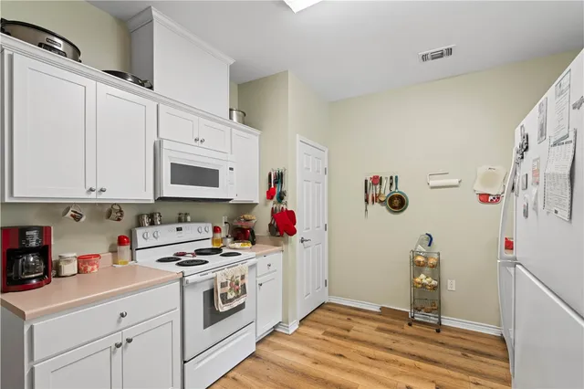 a kitchen with a refrigerator and white cabinets