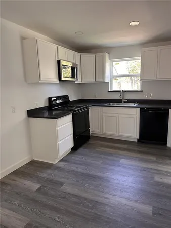 a kitchen with granite countertop wooden floors and stainless steel appliances