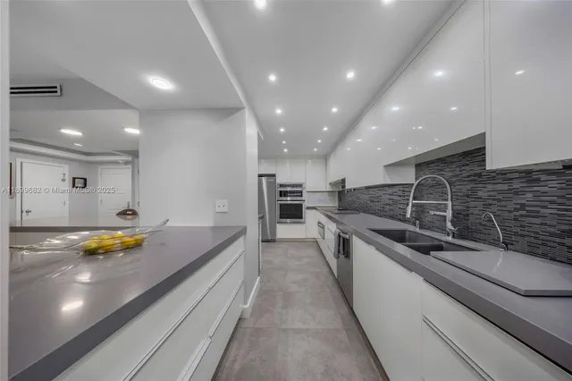 a large kitchen with stainless steel appliances lots of counter top space