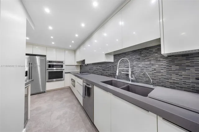 a kitchen with stainless steel appliances granite countertop a sink and refrigerator