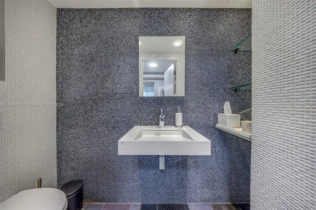a bathroom with a sink a toilet and mirror