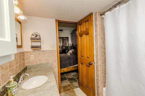 a bathroom with a granite countertop sink and a mirror