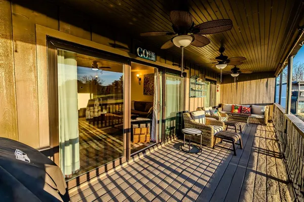 a view of a balcony with chairs and wooden floor