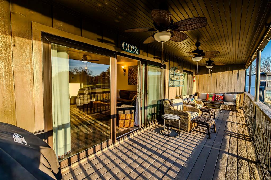 1655 Cedar Crest Loop, Unit E7 Graford, TX 76449 - Photo 2 of 35 a view of a balcony with chairs and wooden floor