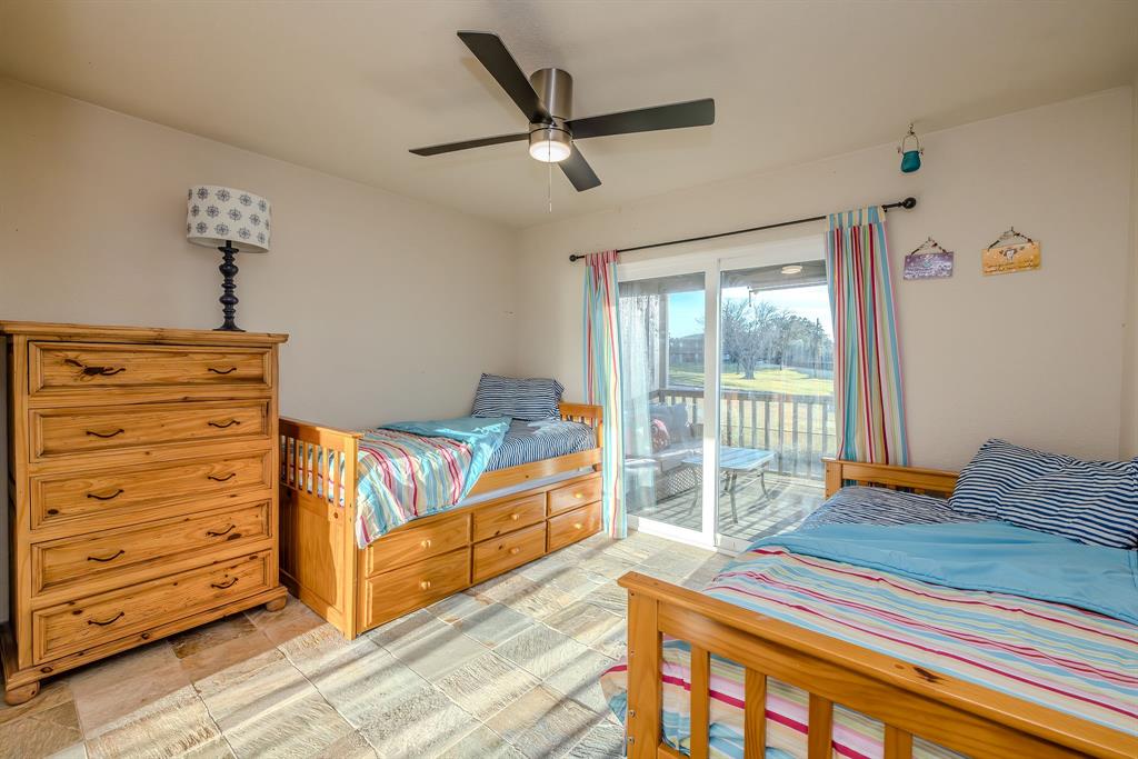 1655 Cedar Crest Loop, Unit E7 Graford, TX 76449 - Photo 20 of 35 a bedroom with a bed and a dresser