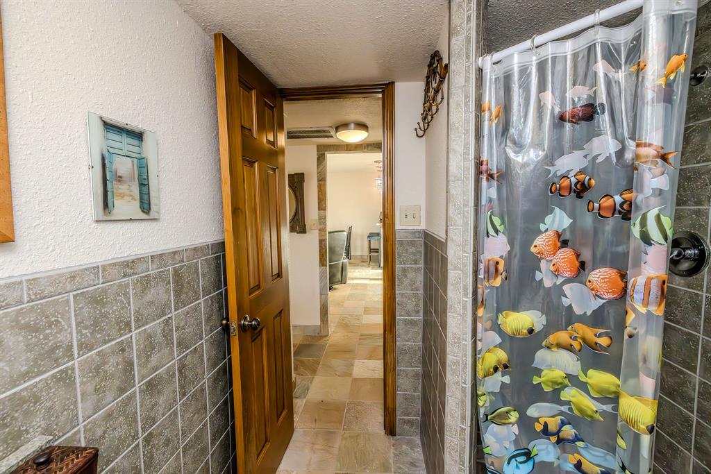 1655 Cedar Crest Loop, Unit E7 Graford, TX 76449 - Photo 24 of 35 a bathroom with a shower and a sink a mirror