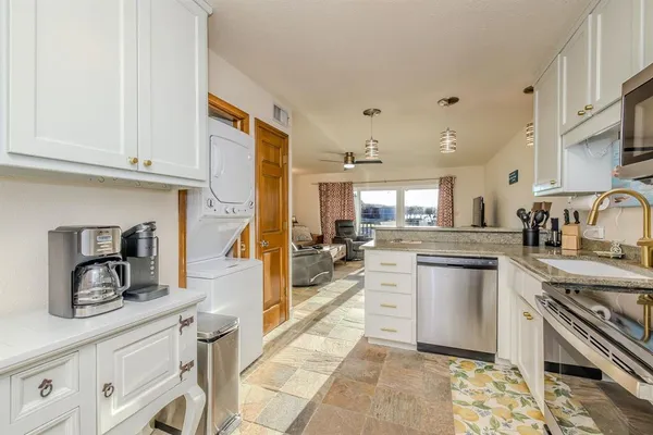 a kitchen with kitchen island granite countertop a sink cabinets and stainless steel appliances
