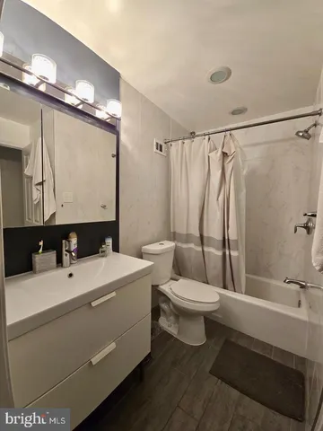 a bathroom with a sink a toilet a mirror and shower