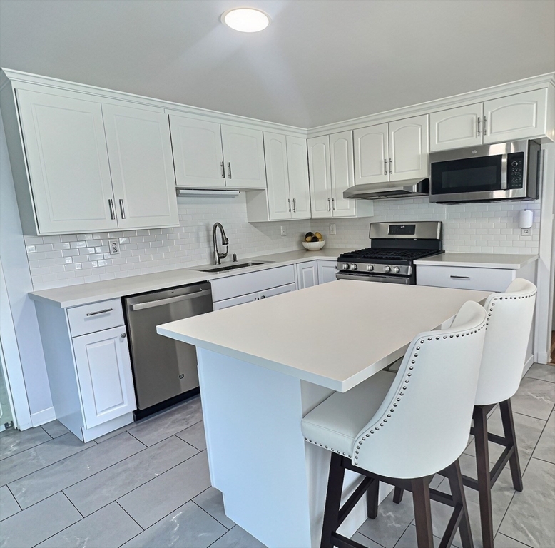 2 McFarlin Road Carver, MA 02330 - Photo 7 of 35 a kitchen with stainless steel appliances a stove a sink a microwave a refrigerator and cabinets