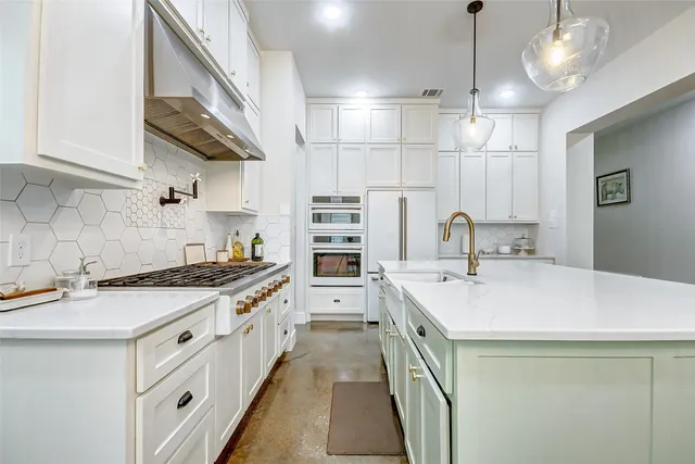 a kitchen with stainless steel appliances a sink stove and cabinets