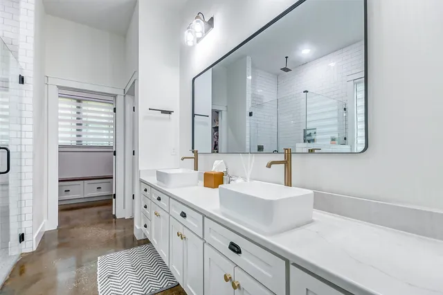 a bathroom with double vanity and a mirror