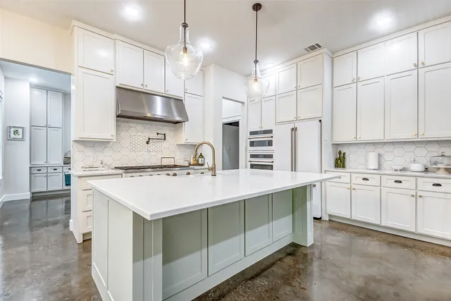 a kitchen with stainless steel appliances white cabinets and a sink