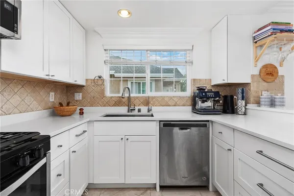 a kitchen with cabinets appliances a sink and a counter top space