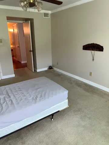 a spacious bedroom with a bed and a dresser