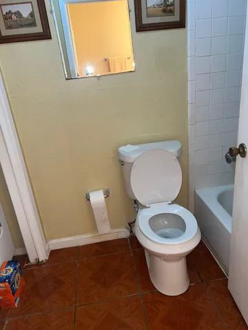 a white toilet sitting next to a bathroom sink and tub