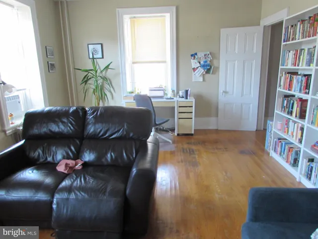 a living room with furniture and a book shelf