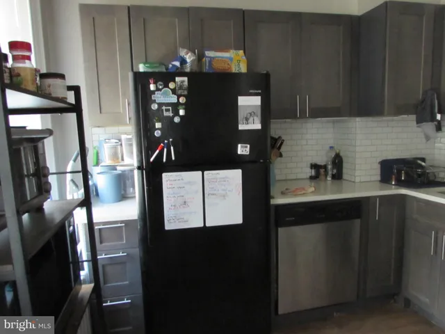 a kitchen with stainless steel appliances kitchen island granite countertop a refrigerator