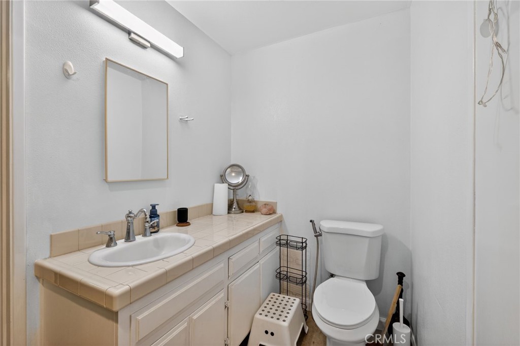 10079 West Lilac Road Escondido, CA 92026 - Photo 28 of 50 a bathroom with a toilet a sink a mirror and vanity