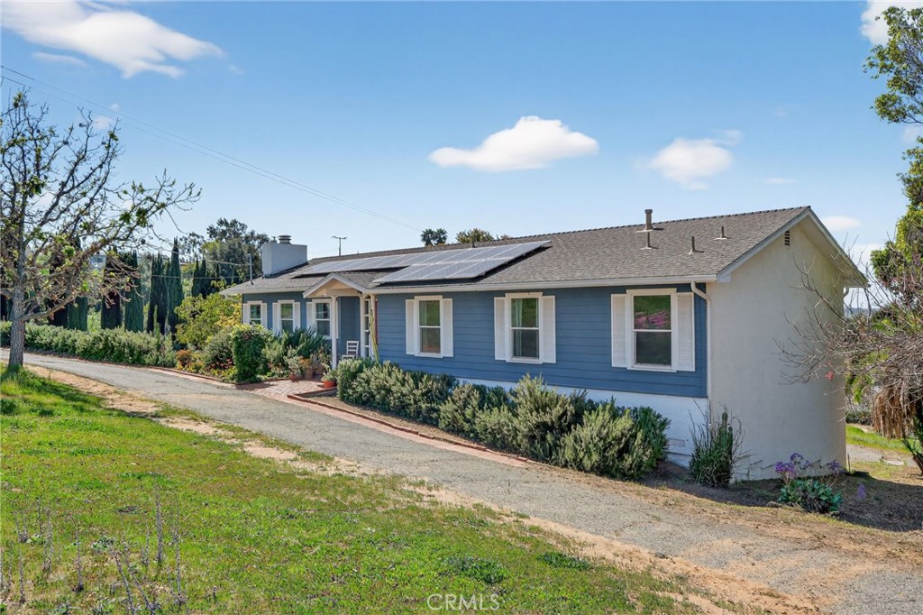10079 West Lilac Road Escondido, CA 92026 - Photo 4 of 50 a front view of a house with a yard and potted plants
