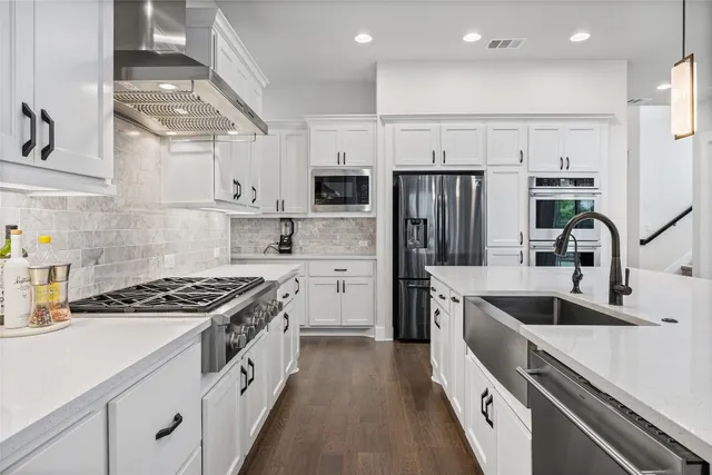 a kitchen with kitchen island stainless steel appliances a sink stove and refrigerator