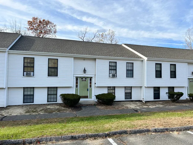 a view of a white house with a swimming pool and a yard