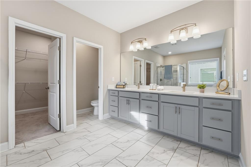 4183 Valtek Court Suwanee, GA 30024 - Photo 33 of 46 a spacious bathroom with a double vanity sink a mirror and a shower