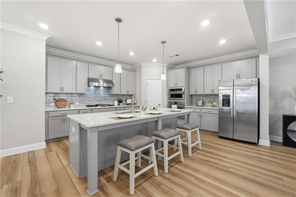 4183 Valtek Court Suwanee, GA 30024 - Photo 10 of 46 a kitchen with kitchen island white cabinets and stainless steel appliances