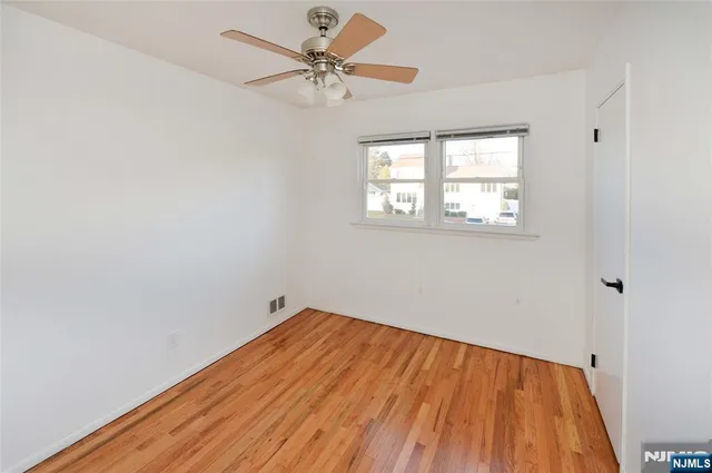 an empty room with a window and wooden floor