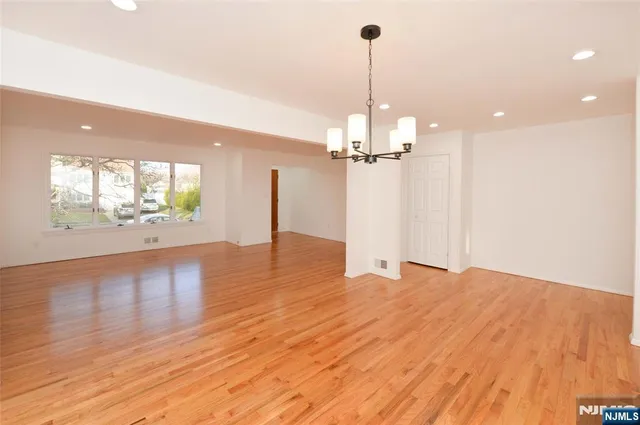 a view of a room with wooden floor staircase and kitchen view