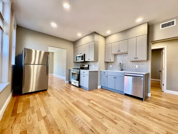a kitchen with stainless steel appliances a refrigerator and a stove