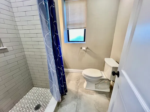 a bathroom with a toilet and a shower