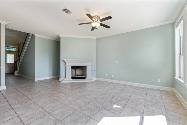 an empty room with fan and windows